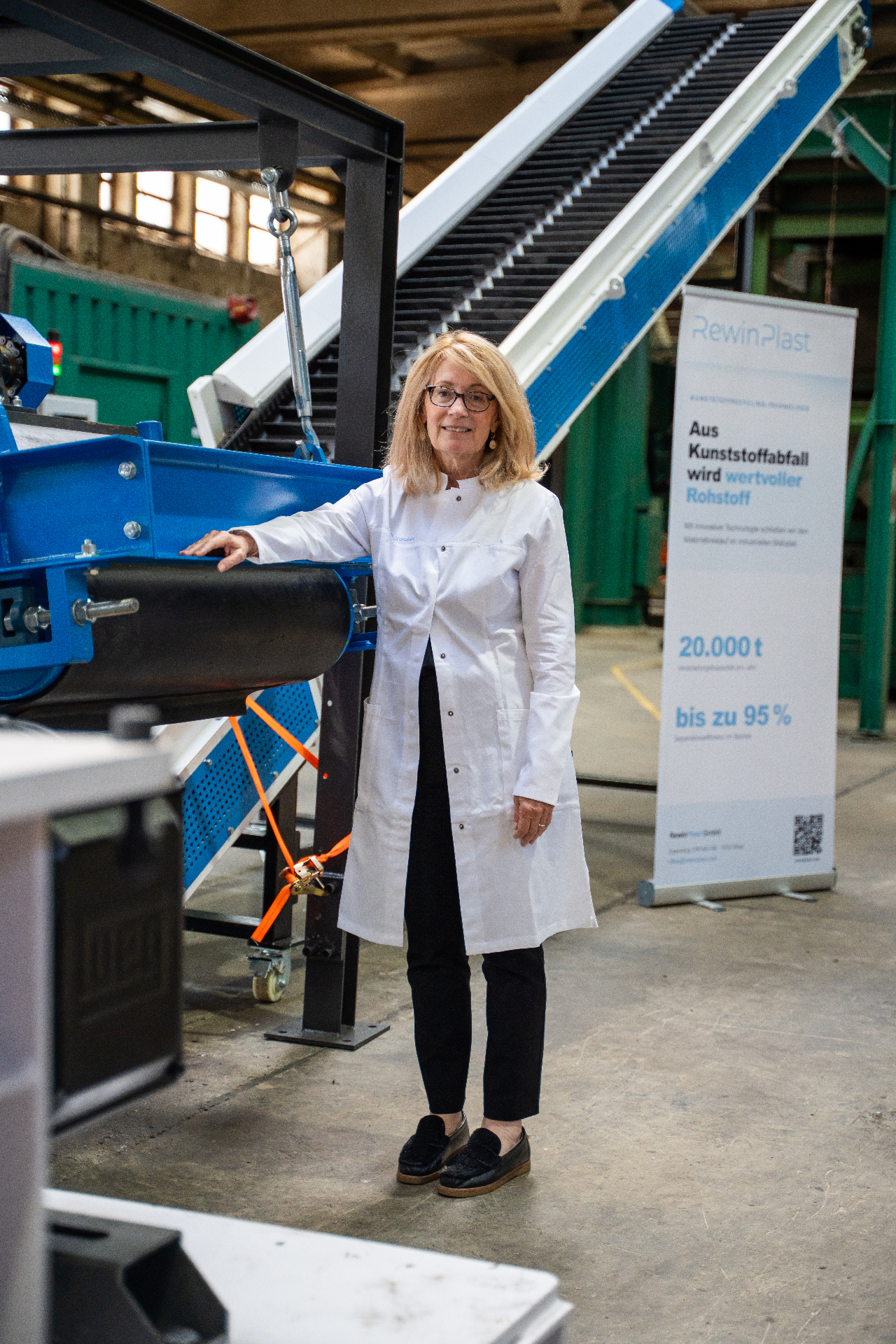 Mitarbeiterin in Laborkittel vor der RewinPlast-Anlage